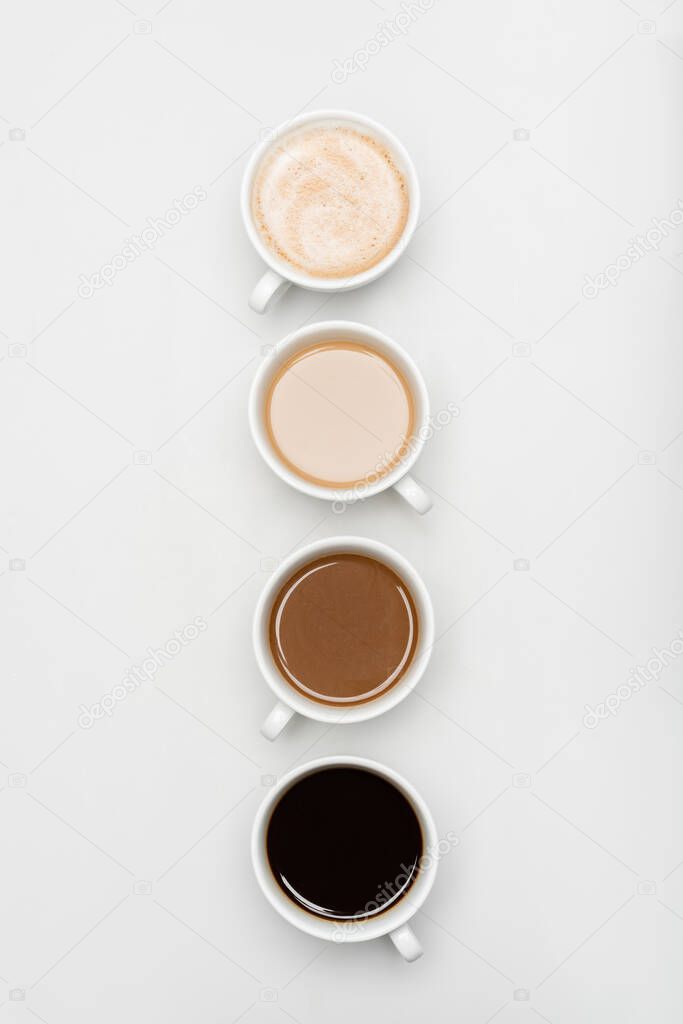 top view of different freshy made coffee drinks with milk on white