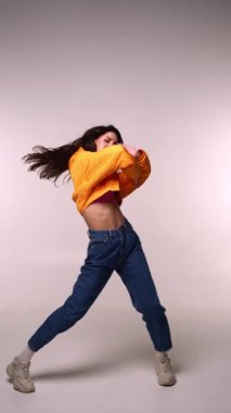 Gri arka planda modaya uygun dansçı 