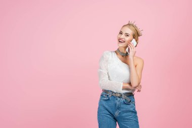 Lüks tacın içinde mutlu bir kadın. Pembelerden izole bir şekilde akıllı telefondan konuşuyor.