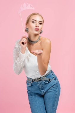 Çubukta kağıt taç tutan şık bir kadın ve pembe üzerine hava öpücüğü yollayan.