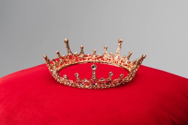 luxury crown on red velvet cushion isolated on grey clipart