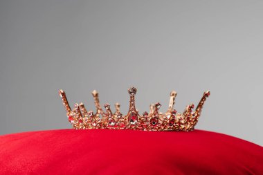 royal crown on red velvet cushion isolated on grey clipart