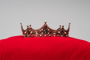 luxury crown on red velvet cushion isolated on grey clipart