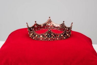 luxury royal crown on red cushion isolated on grey clipart