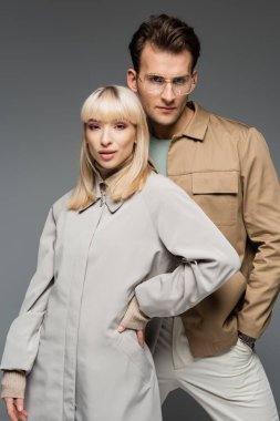 Gri renkte tek başına ayakta duran genç moda modelleri