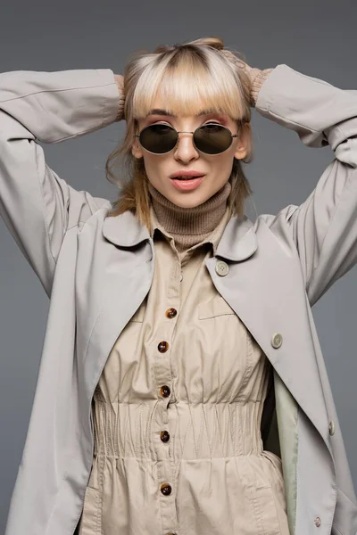 Trendy Junge Frau Sonnenbrille Und Trenchcoat Posiert Isoliert Auf Grau — Stockfoto