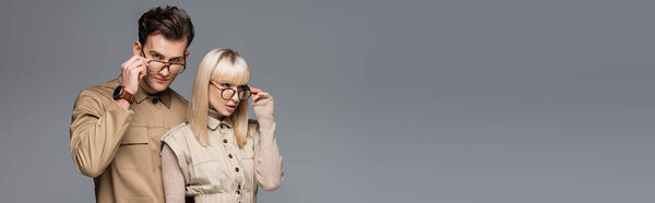 стильные модели регулировки очков и позирование изолированы на сером, баннер