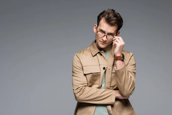 Hombre Moda Chaqueta Ajustando Gafas Mientras Posando Aislado Gris — Foto de Stock