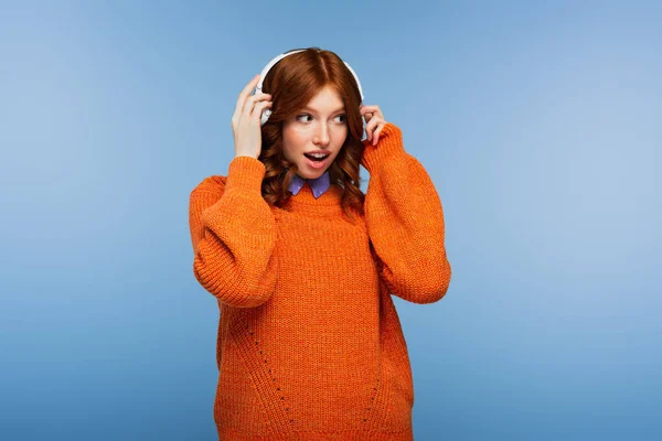 Mujer Pelirroja Sorprendida Escuchando Música Auriculares Inalámbricos Aislados Azul — Foto de Stock