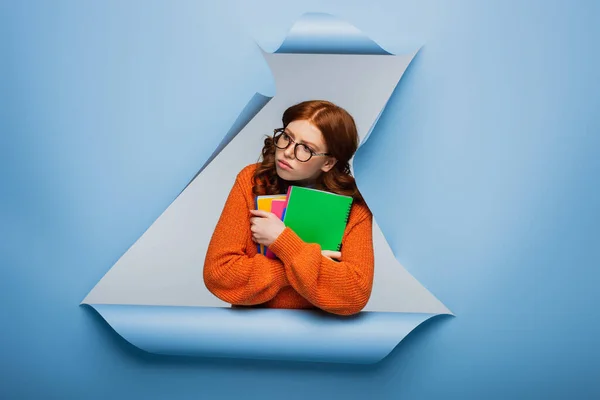 Redhead Student Orange Sweater Glasses Holding Textbooks Blue Ripped Paper — Stock Photo, Image