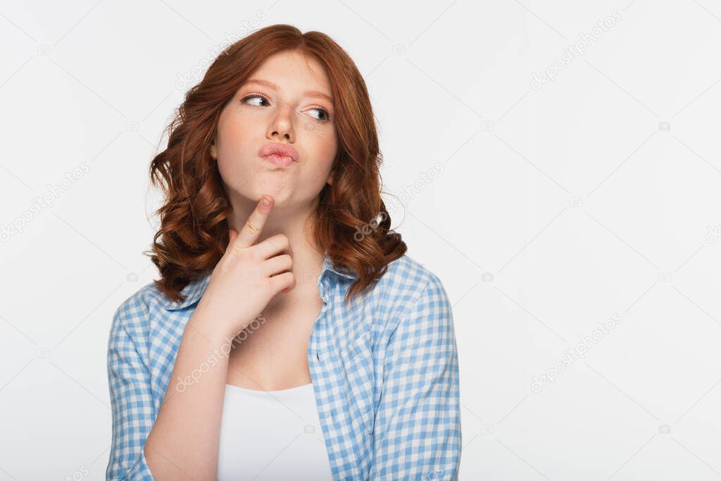 pensive young redhead woman in blue plaid shirt looking away isolated on white