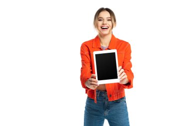 Turuncu gömlekli, kot pantolonlu, elinde beyaz ekranlı dijital tablet tutan neşeli genç bir kadın.
