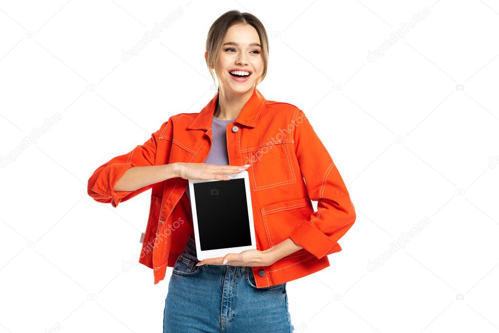 happy young woman in orange shirt and jeans holding digital tablet with blank screen isolated on white