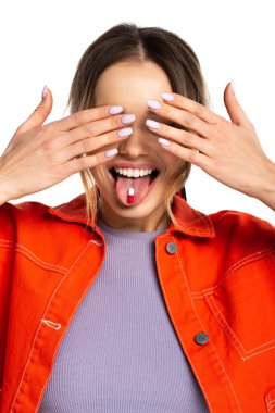 young woman covering eyes and sticking out tongue with capsule isolated on white  clipart