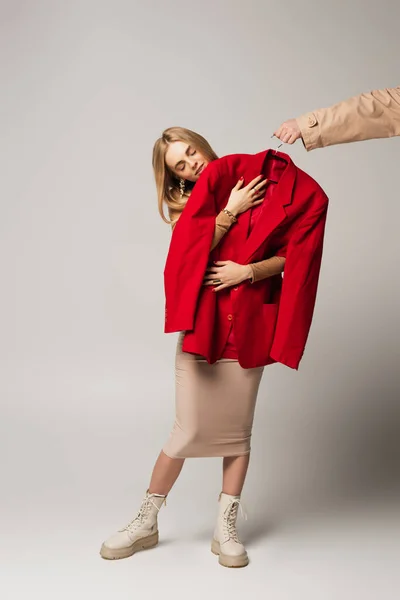 Mujer Sosteniendo Chaqueta Cerca Hombre Con Percha Sobre Fondo Gris — Foto de Stock