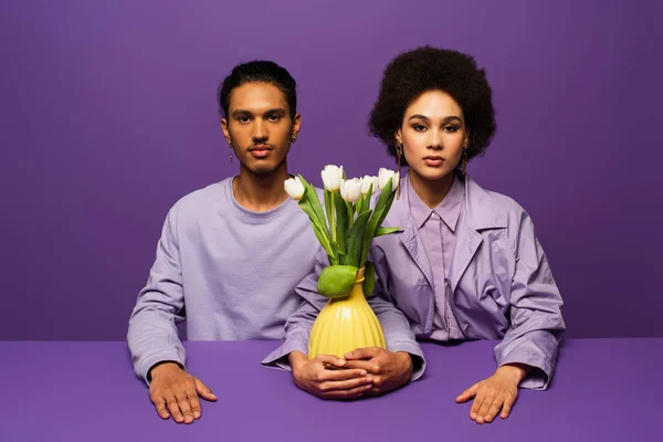 Trendy Young African American Couple Sitting Vase Tulips Isolated Purple — Stock Photo, Image