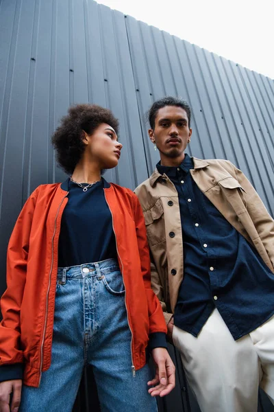 Низкий Угол Обзора Африканской Американской Пары Модных Куртках Позирующих Снаружи — стоковое фото