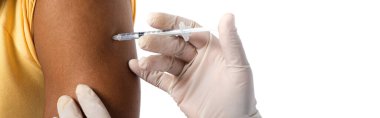 Beyaz pankartta izole edilmiş Afrikalı Amerikalılara aşı enjekte eden lateks eldivenli doktor görüntüsü.  