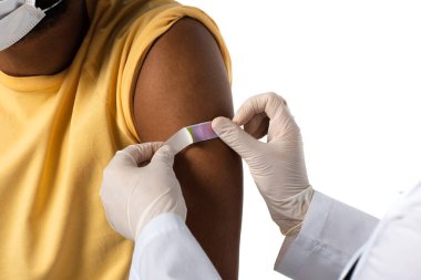 Beyazlar üzerinde izole edilmiş Afrikalı Amerikalı bir hastanın koluna yapıştırıcı sürerken doktorun görüşü kesilmiş. 