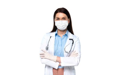 Doktor maske takmış, kolları çapraz duran, beyaz tenli. 