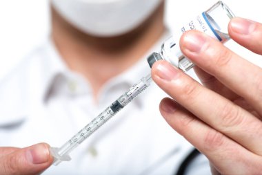 Close up view of syringe and vaccine in hands of blurred doctor isolated on white  clipart