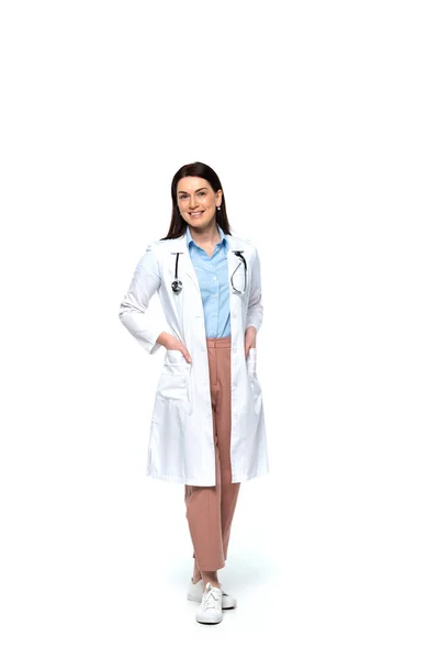 Lächelnder Arzt Hält Hände Taschen Aus Weißem Mantel Auf Weißem — Stockfoto