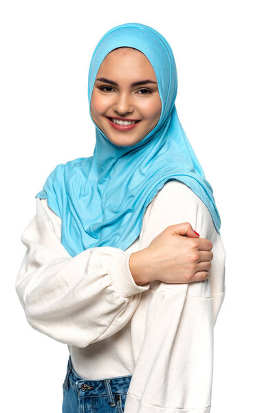 Smiling arabian woman in blue hijab looking at camera isolated on white 