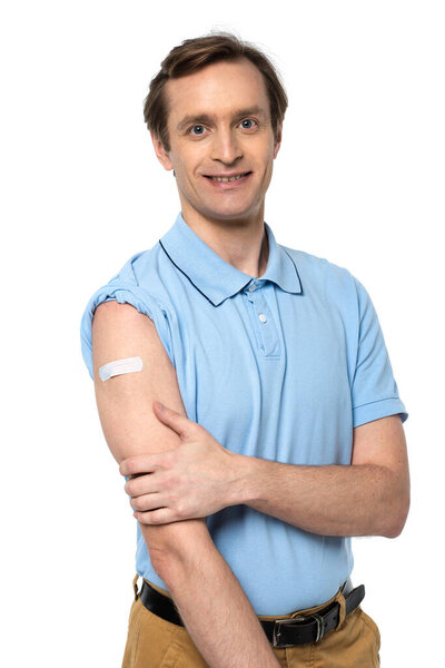 Cheerful man with adhesive patch on arm smiling at camera isolated on white 