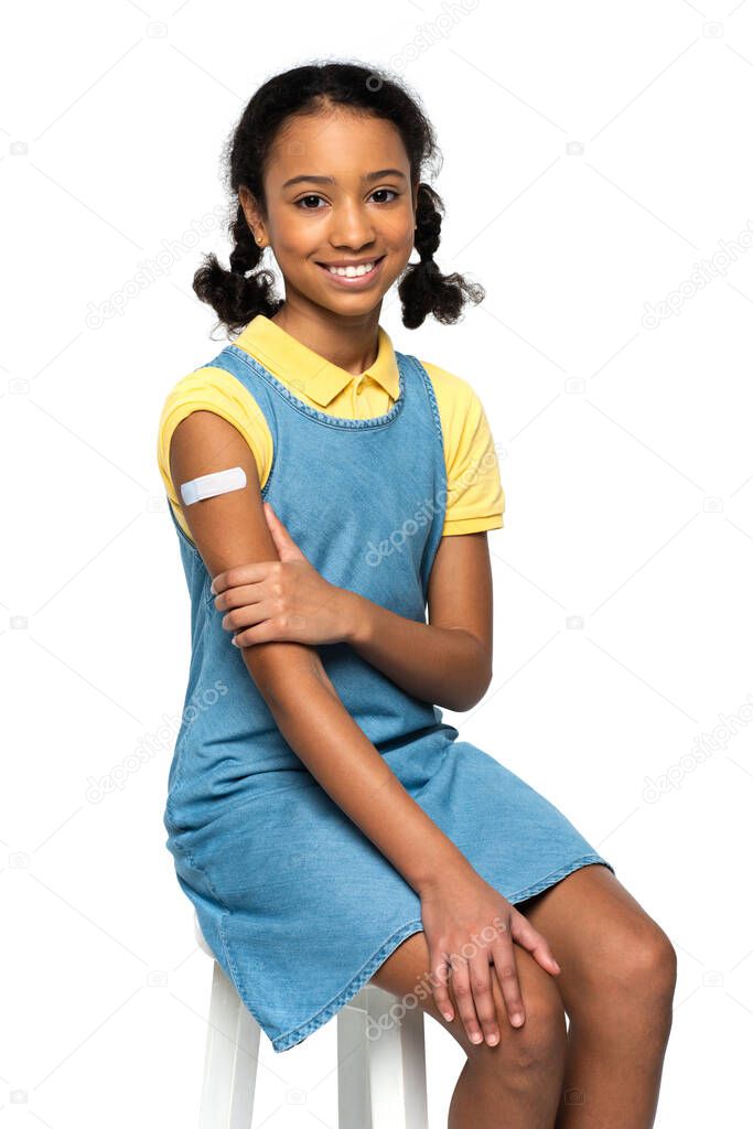 Smiling african american kid with adhesive patch on arm isolated on white 