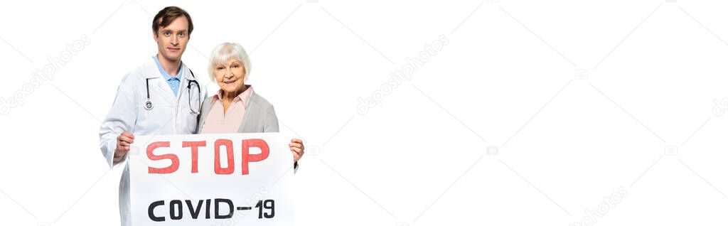 Senior patient and doctor holding placard with stop covid-2019 lettering isolated on white, banner 