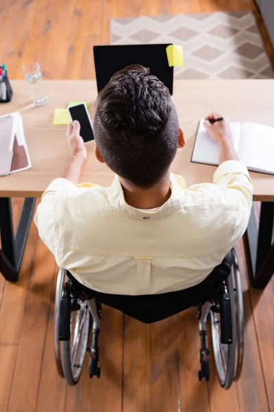 Vista Aérea Del Hombre Discapacitado Escribiendo Cuaderno Mientras Trabaja Cerca — Foto de Stock