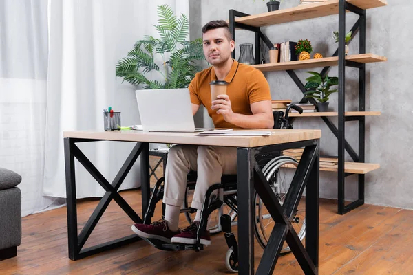 Evde Dizüstü Bilgisayarın Yanında Çalışırken Elinde Kahve Tutan Engelli Adam — Stok fotoğraf