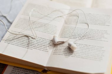 Bulanık kitaplardaki beyaz kulaklıkları kapat