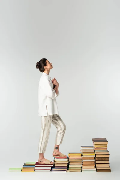 Full Length Young Tattooed Woman Looking While Standing Pile Books — Stock Photo, Image