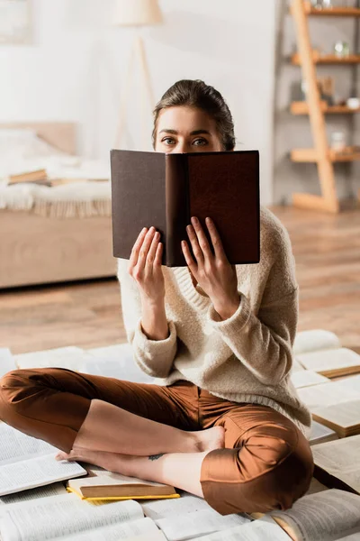 Mujer Oscureciendo Cara Mientras Está Sentado Montón Libros — Foto de Stock