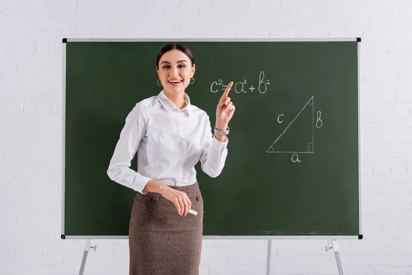 Leende Lärare Pekar Med Fingret Nära Tavlan Med Matematisk Formel — Stockfoto