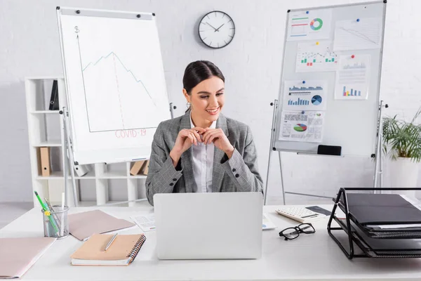 Vrolijke Zakenvrouw Zoek Naar Rekenmachine Buurt Van Kranten Laptop Tafel — Stockfoto