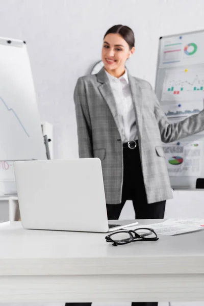 Laptop Eyeglasses Smiling Businesswoman Flipchart Blurred Background — Stock Photo, Image