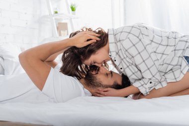 Yatakta gözleri kapalı yatan mutlu ırklar arası bir çift.