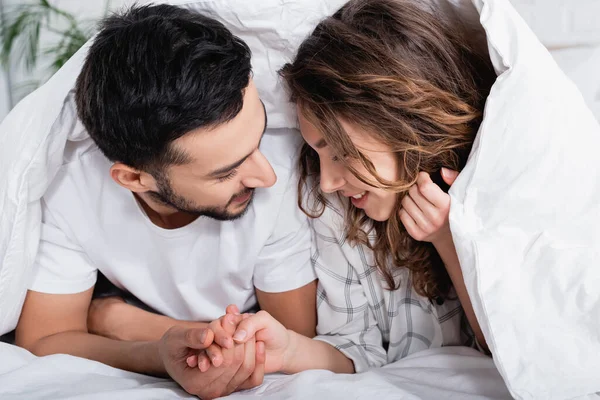 Smiling Interracial Couple Holding Hands While Lying Blanket — Stock Photo, Image