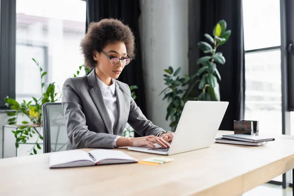 Afrykański Amerykański Bizneswoman Pracuje Laptopie Pobliżu Zamazanego Notebooka — Zdjęcie stockowe