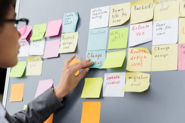 African american businesswoman on blurred foreground applying sticky note  clipart