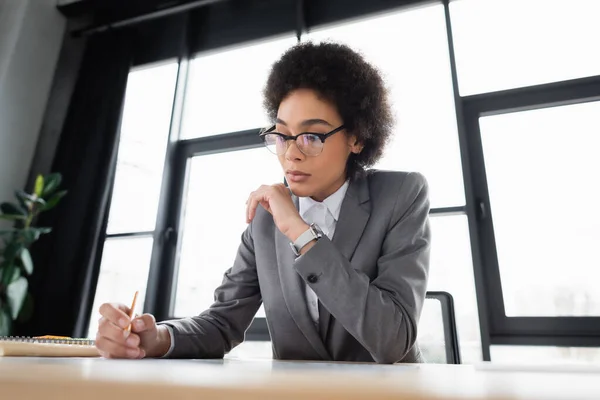 Afrikanischer Manager Hält Bleistift Der Nähe Von Verschwommenem Arbeitstisch — Stockfoto