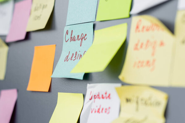 Colorful sticky notes with lettering on board in office 