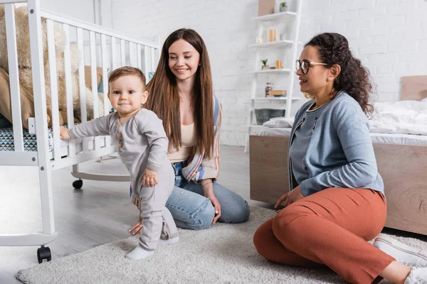 Omtänksam Mor Tittar Spädbarn Pojke Nära Leende Afrikansk Amerikansk Vän — Stockfoto