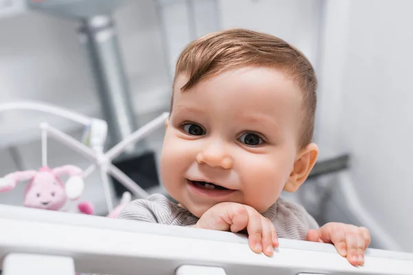 Primer Plano Niño Sonriente Mirando Cámara Desde Cuna —  Fotos de Stock