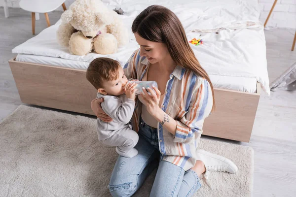 Mãe Jovem Feliz Alimentando Filho Bebê Com Leite Garrafa — Fotografia de Stock