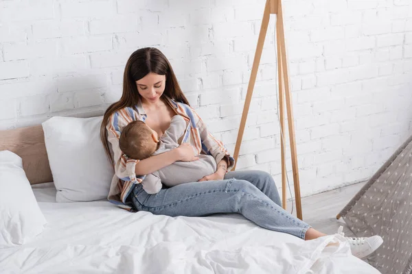 Carinhoso Jovem Mãe Segurando Nos Braços Bebê Menino Cama — Fotografia de Stock