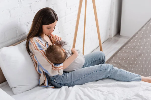 Cuidar Jovem Mãe Segurando Nos Braços Beijando Mão Menino Cama — Fotografia de Stock