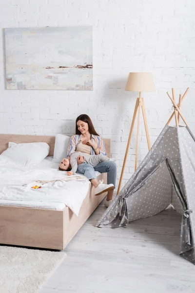 Caring Young Mother Holding Arms Happy Baby Boy Bed — Stock Photo, Image